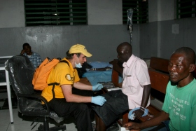 David die zich ontfermt over een patiënt in het ziekenhuis van Port-au-Prince op Haïti